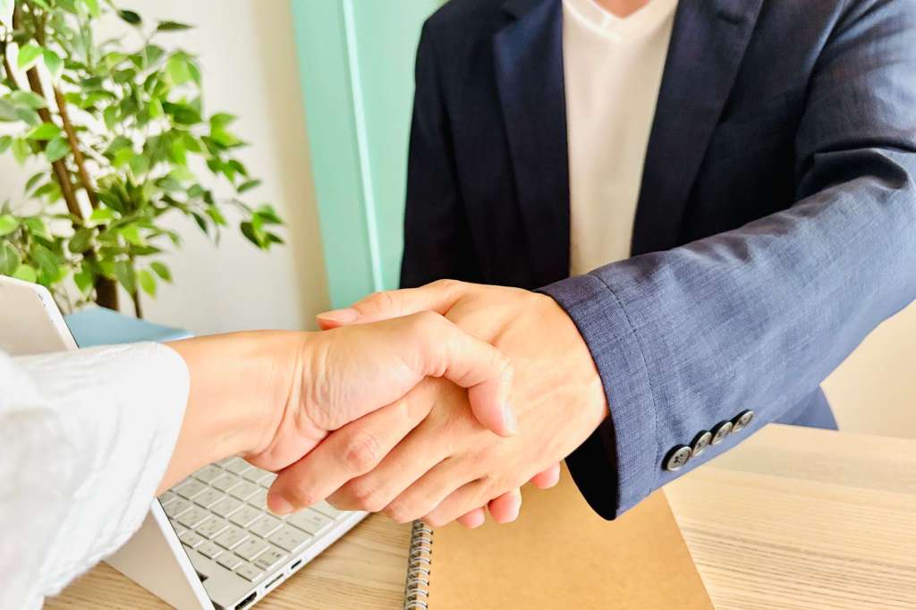 成立して握手する営業マン